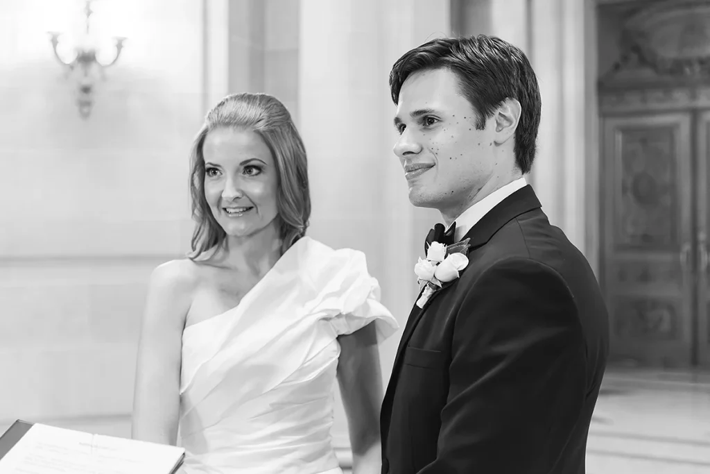 Couple smile at officiant during ceremony