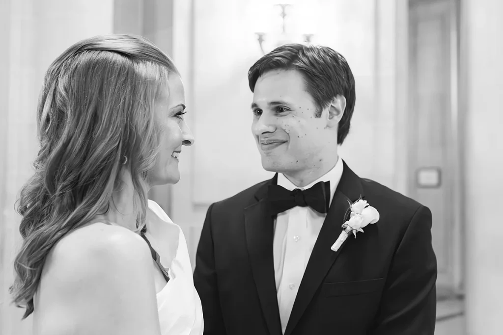 Groom smiles at bride during wedding ceremony