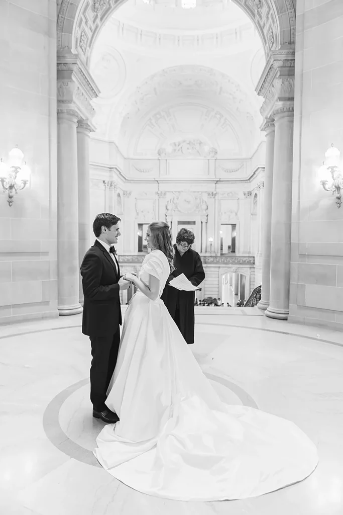 Bride and groom hold hands during City Hall SF civil ceremony wedding ceremony