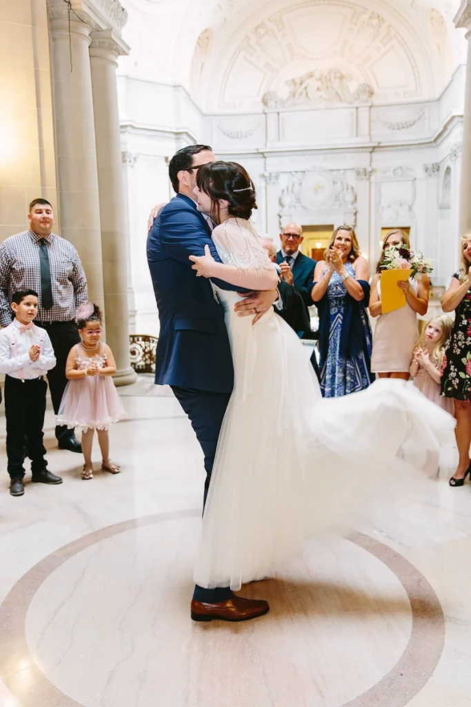 Groom lifts up bride at their City Hall SF wedding