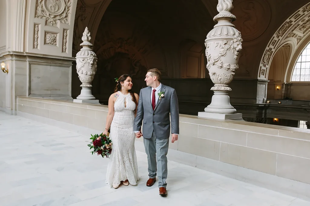 Bride and groom walk together on the Fourth Floor of City Hall SF