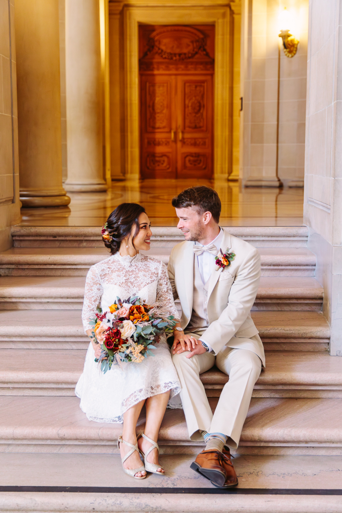 Couple smile at each other sitting on stairs
