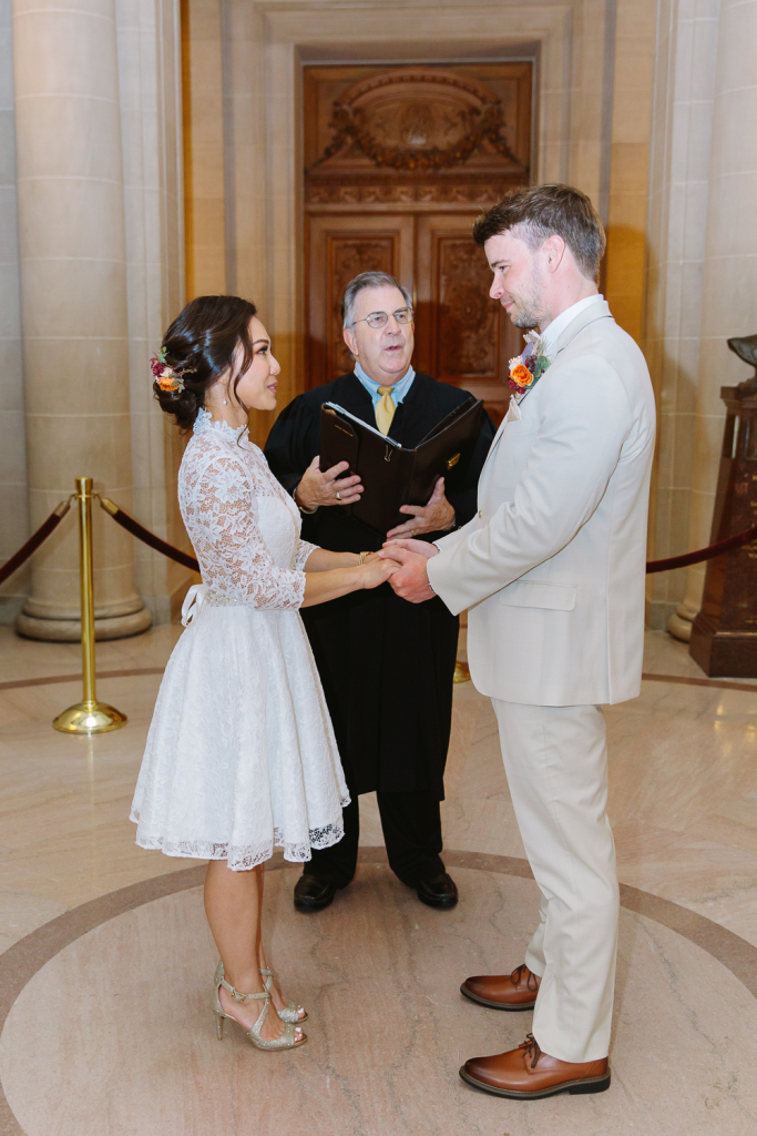Couple hold hands during wedding ceremony