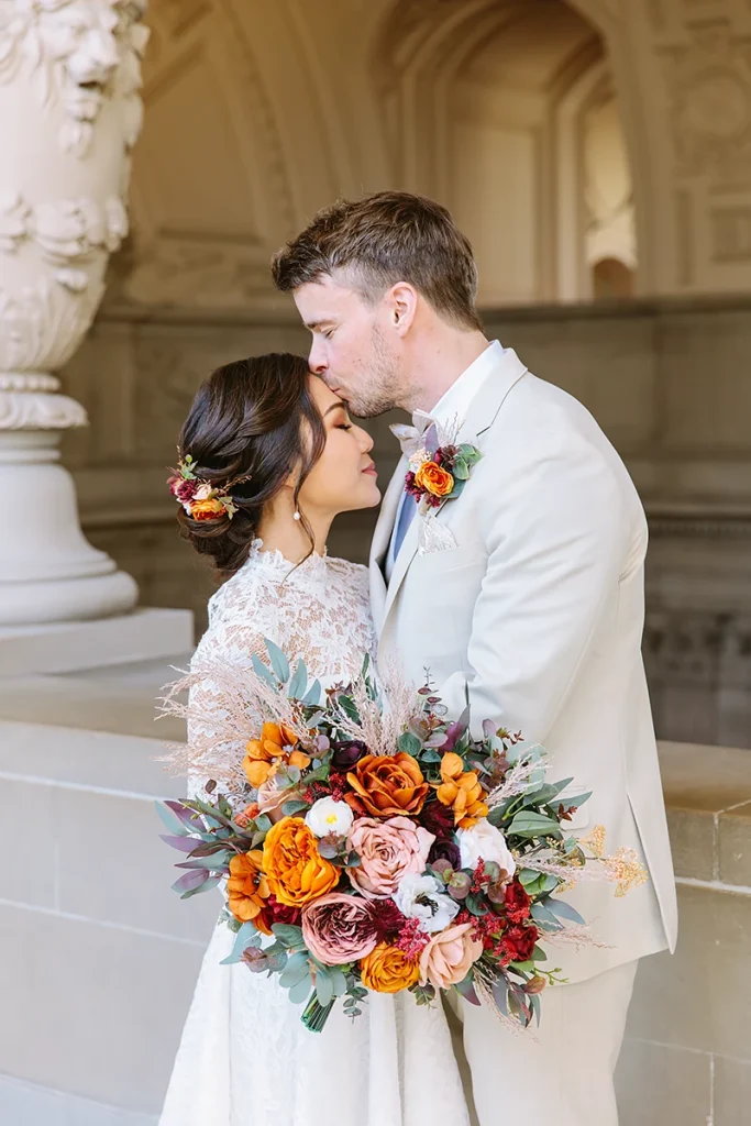 Groom kisses bride on her forehead