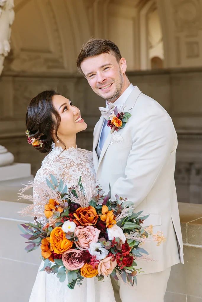 Groom smiles while bride looks at him
