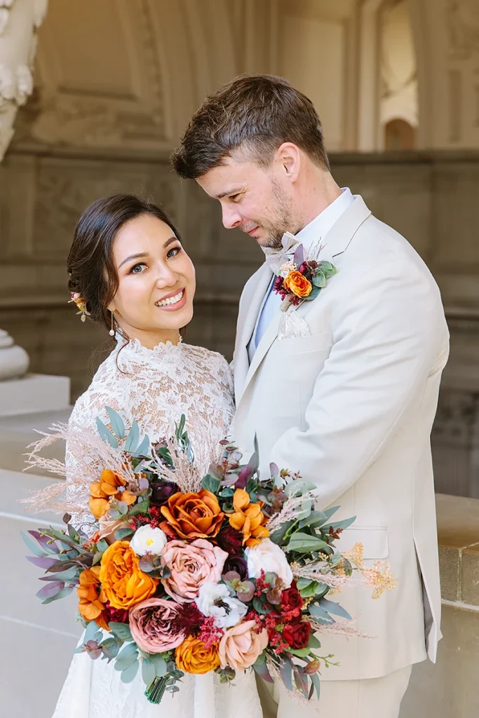 Bride smiles while groom looks at her