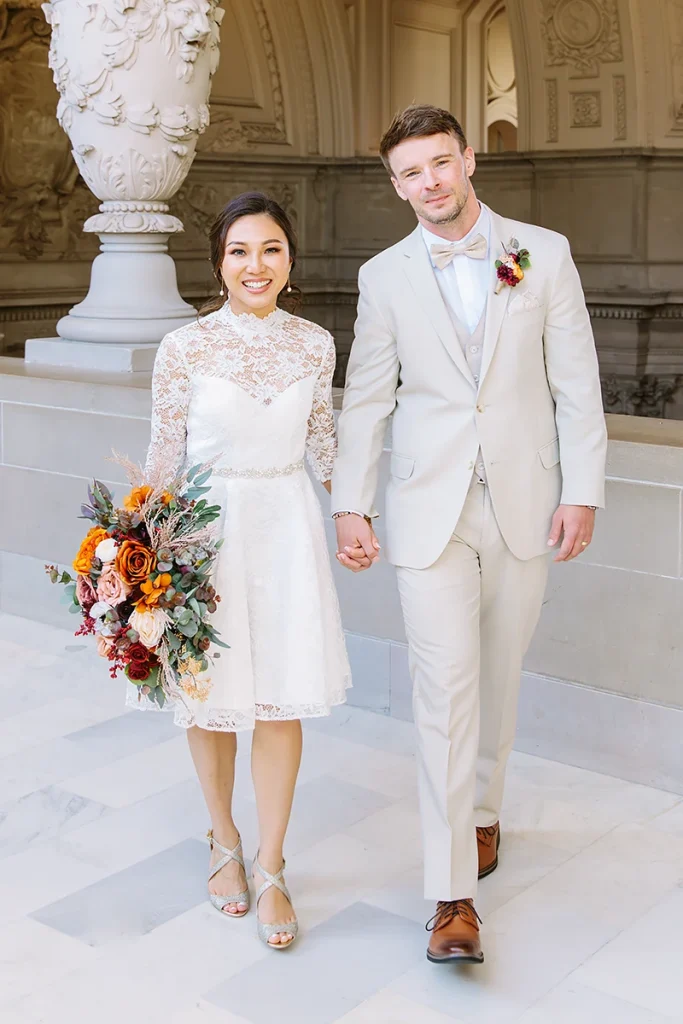 Couple hold hands and smile at City Hall civil ceremony