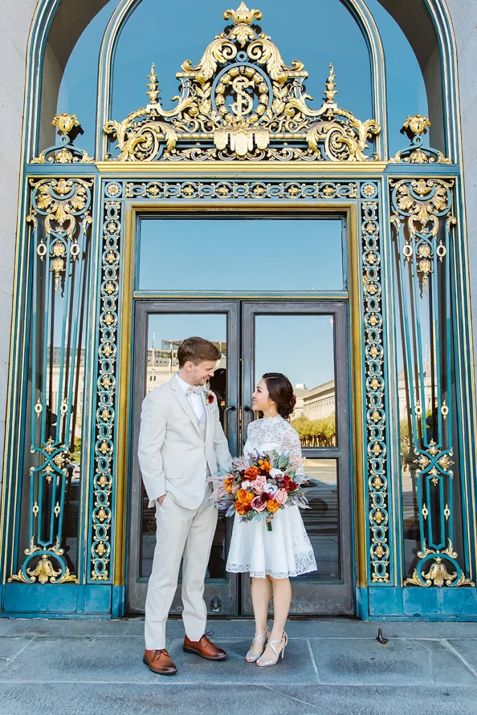 Couple stand together at the front door of City Hall SF