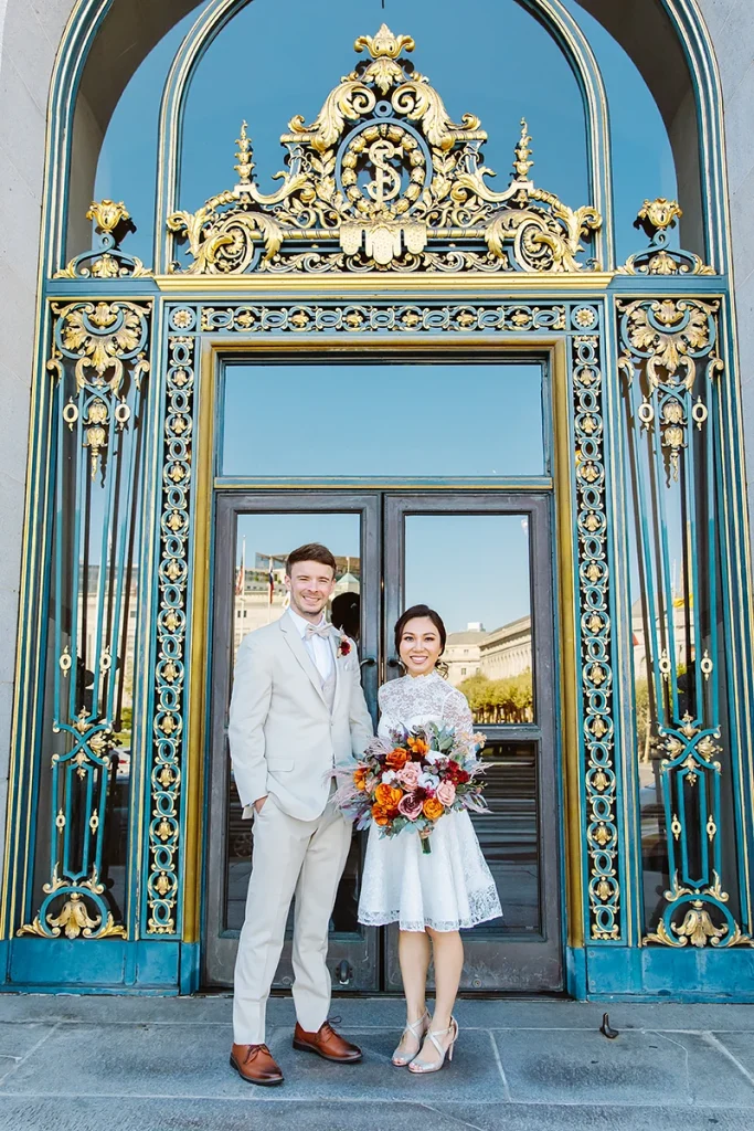 Couple stand together at City Hall front doors
