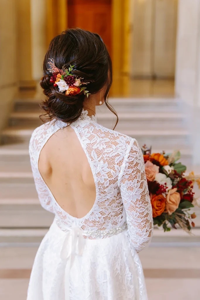 Detail photo of bridal accessories including flowers placed in hair and beaded belt.