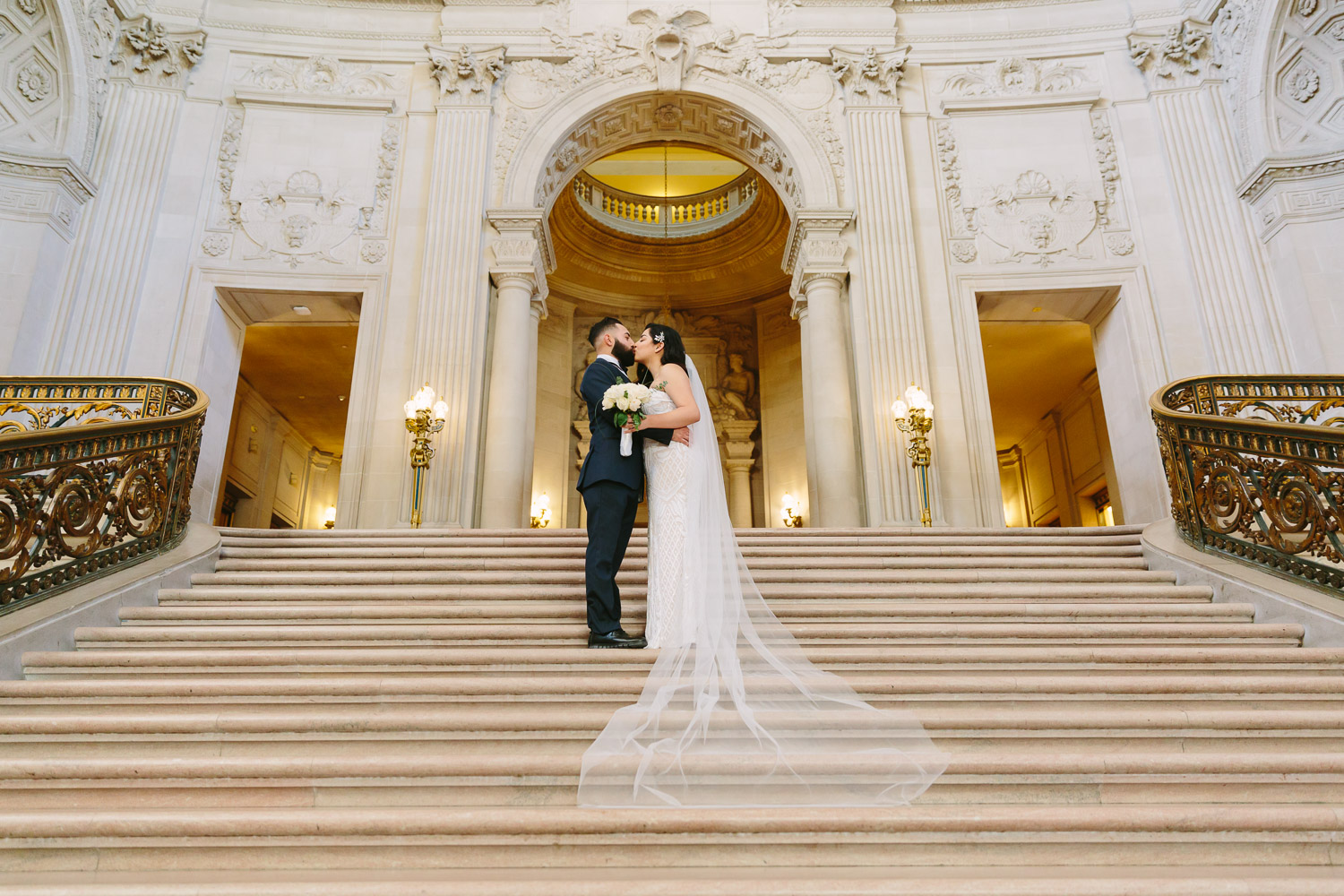 Bride and groom kiss on the Grand Staircase at City Hall