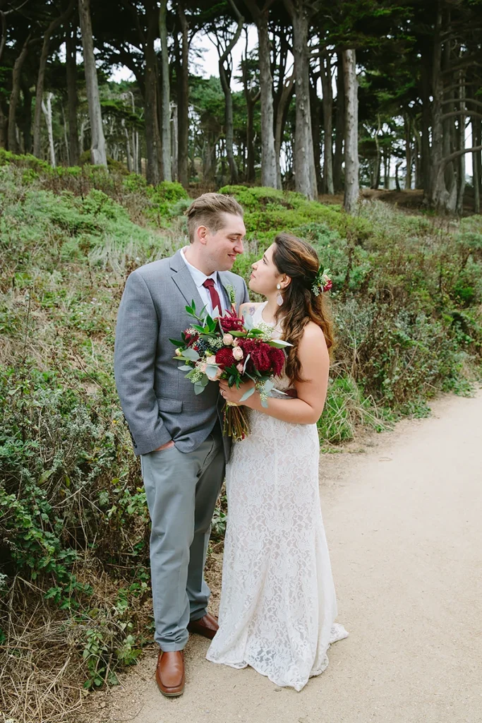 Bride and groom walk on path at Lands End in San Francisco