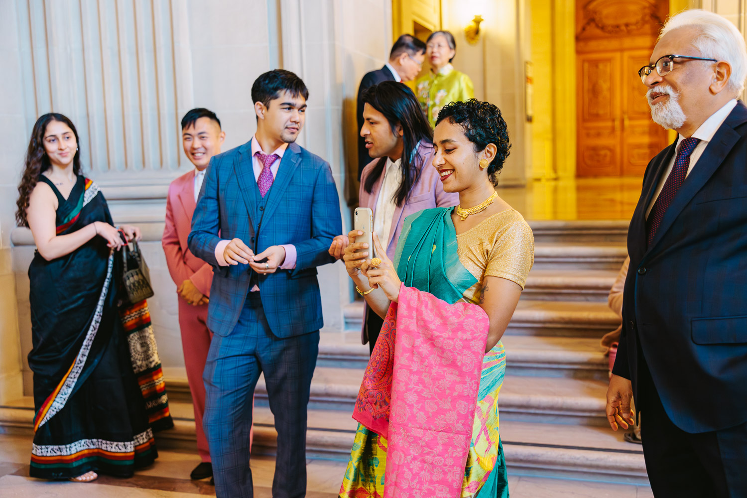 Guests take pictures of the married couple at a lgtbq queer wedding at San Francisco City Hall