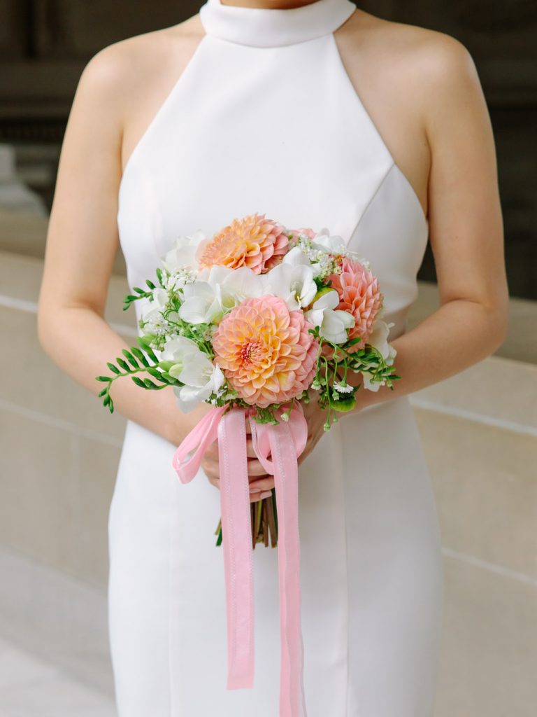 Beautiful bridal bouquet with dahlia flowers and pale pink ribbon