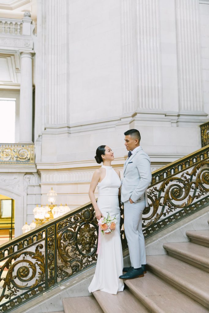 Bride and groom standing on the Grand Staircase at Wedding Ceremony on the Fourth Floor at San Francisco City Hall
