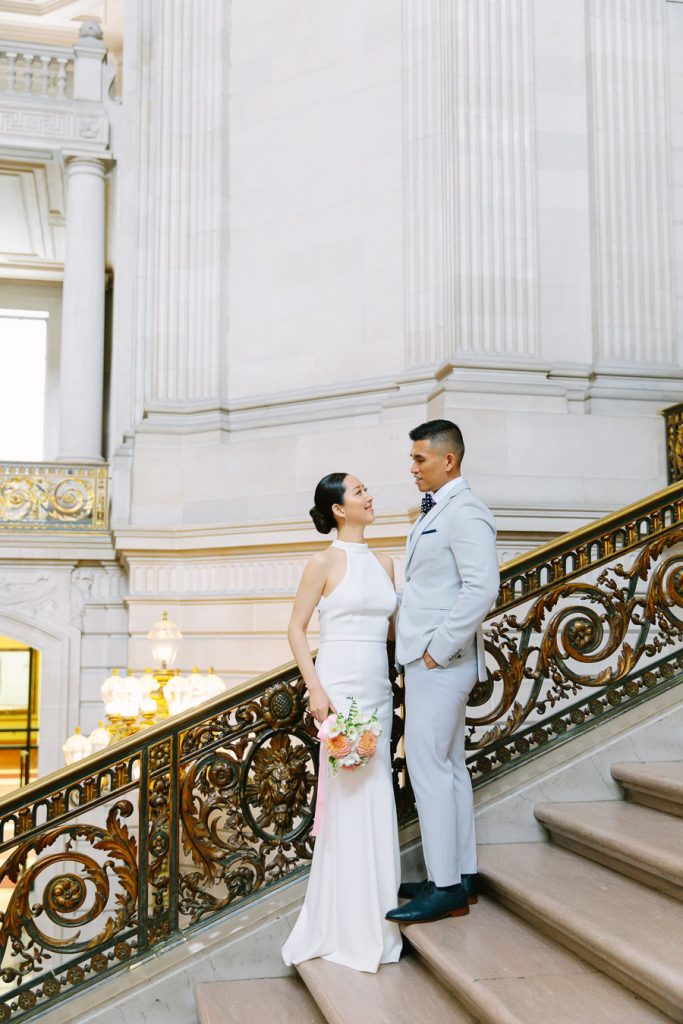 Bride and groom standing on Grand Staircase inside Wedding Ceremony on the Fourth Floor at San Francisco City Hall