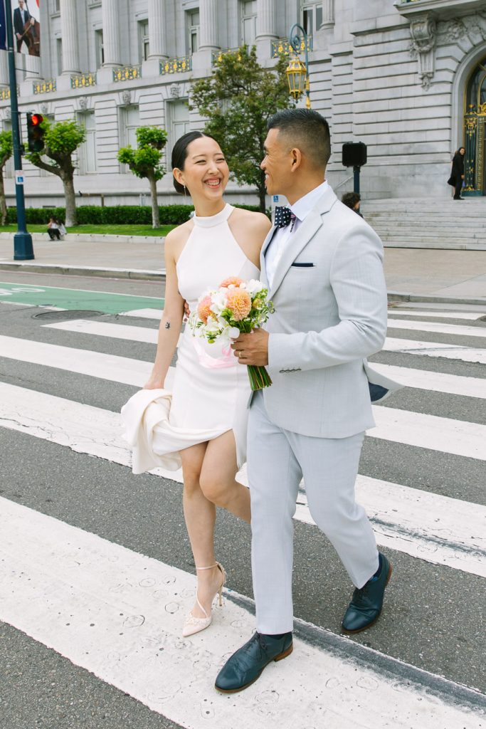 Bride and groom crossing the street in front of Wedding Ceremony on the Fourth Floor at San Francisco City Hall