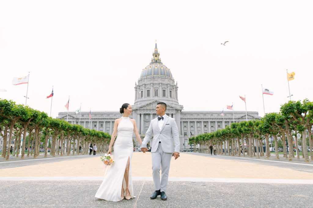 Bride and groom walking in front of Wedding Ceremony on the Fourth Floor at San Francisco City Hall