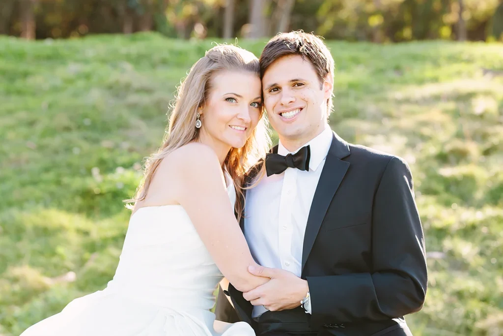 Bride and groom sit down and hug smiling