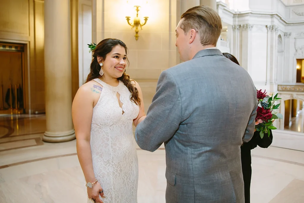 Bride smiles at groom during wedding vows