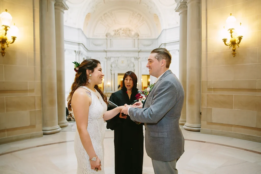 Groom places ring on brides hand