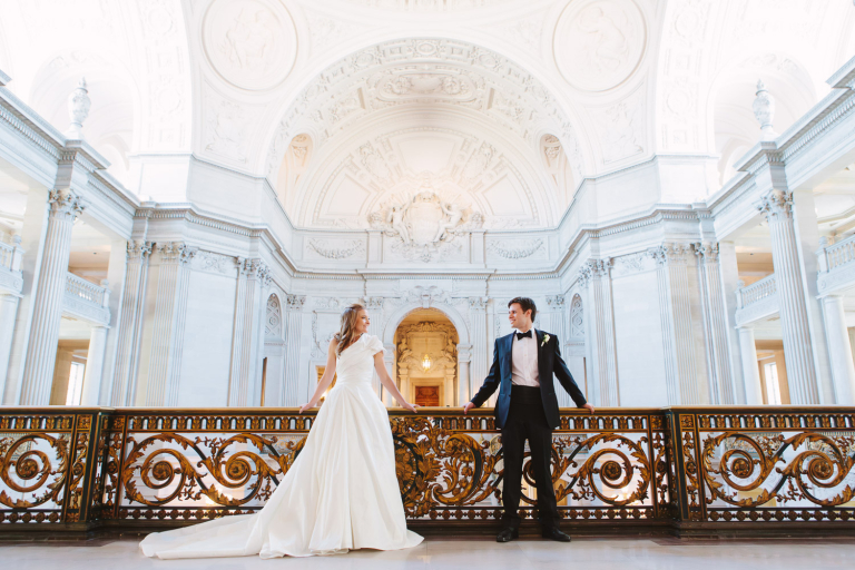 Bride and groom stand together. SF City Hall Mayors Balcony weddings