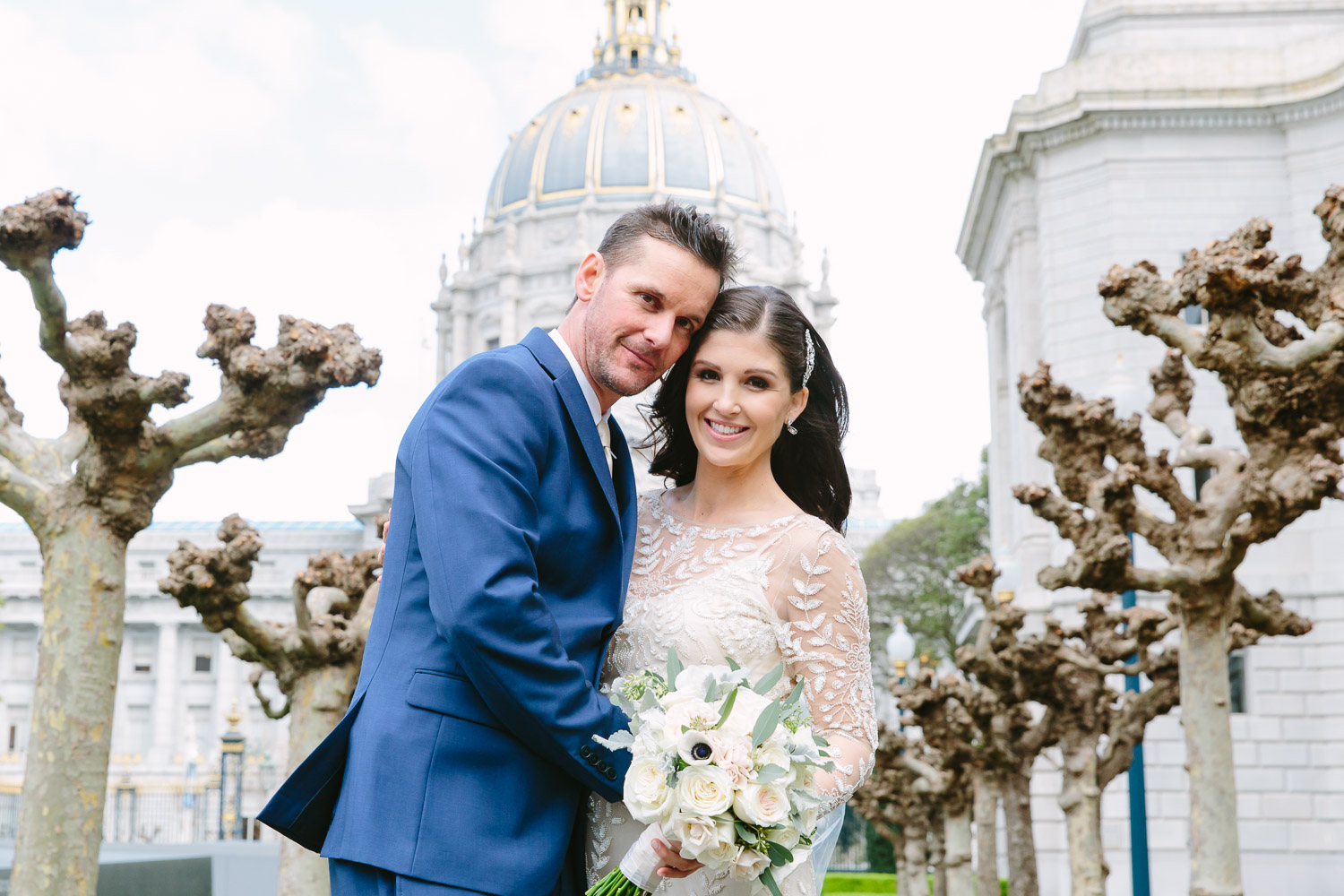 Bride and groom hug at Memorial Court across from SF City Hall