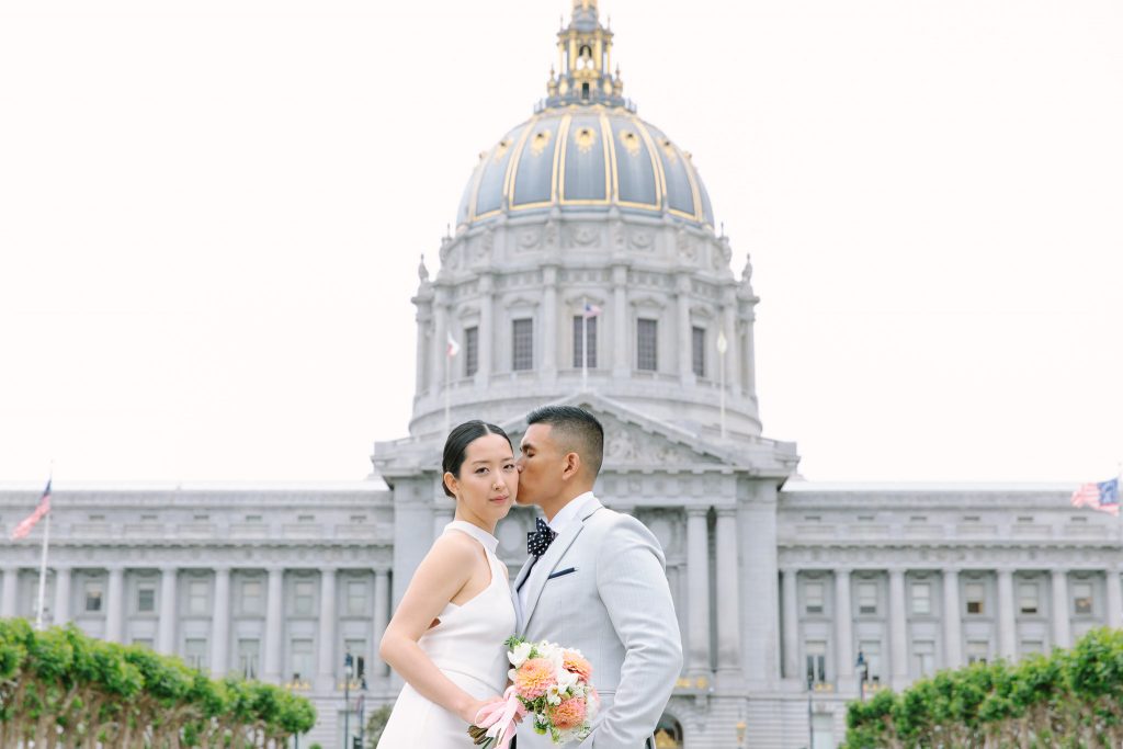 Groom whispers in his brides ear at their SF City Hall wedding