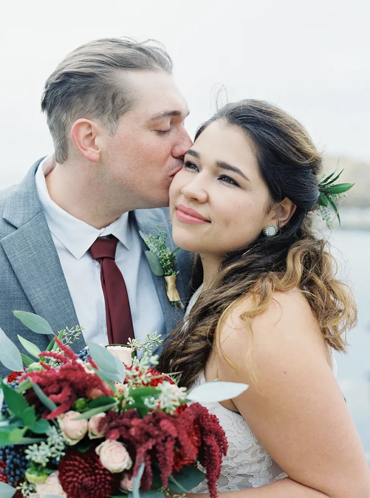 Groom kisses bride on her cheek