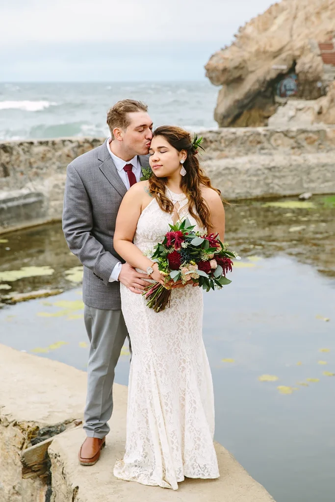 Groom embraces bride